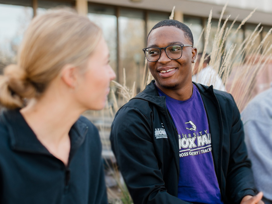 Two students talking to each other on campus